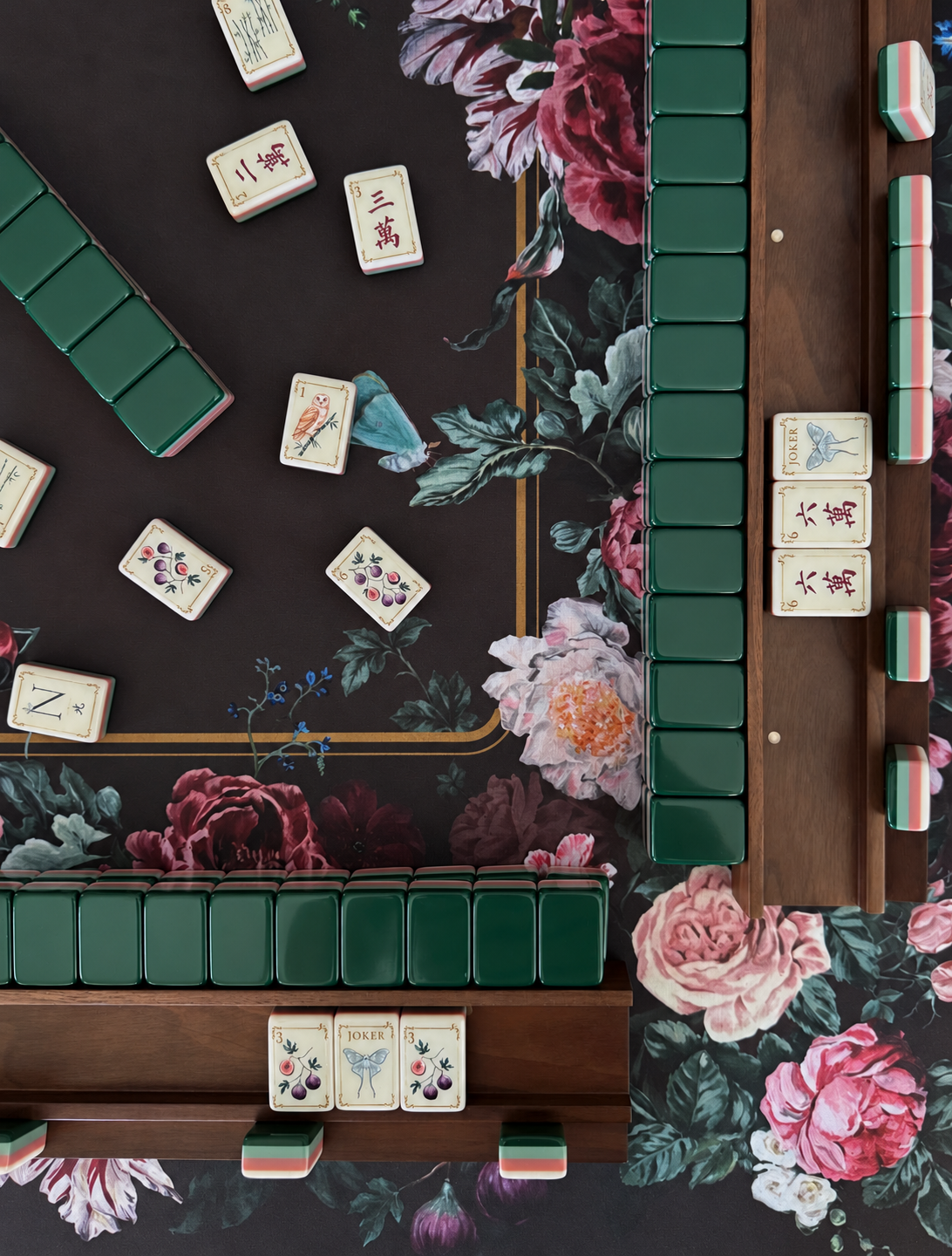 Emerald green American Mahjong tiles arranged on a floral mat